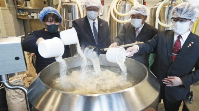 陽光桜ビールの仕込み作業をする出席者＝５日、東京都大田区で
