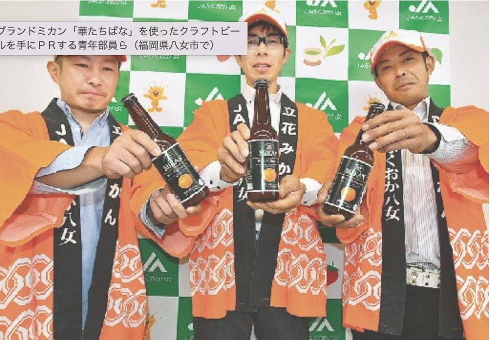ブランドミカン「華たちばな」を使ったクラフトビールを手にPRする青年部員ら（福岡県八女市で）